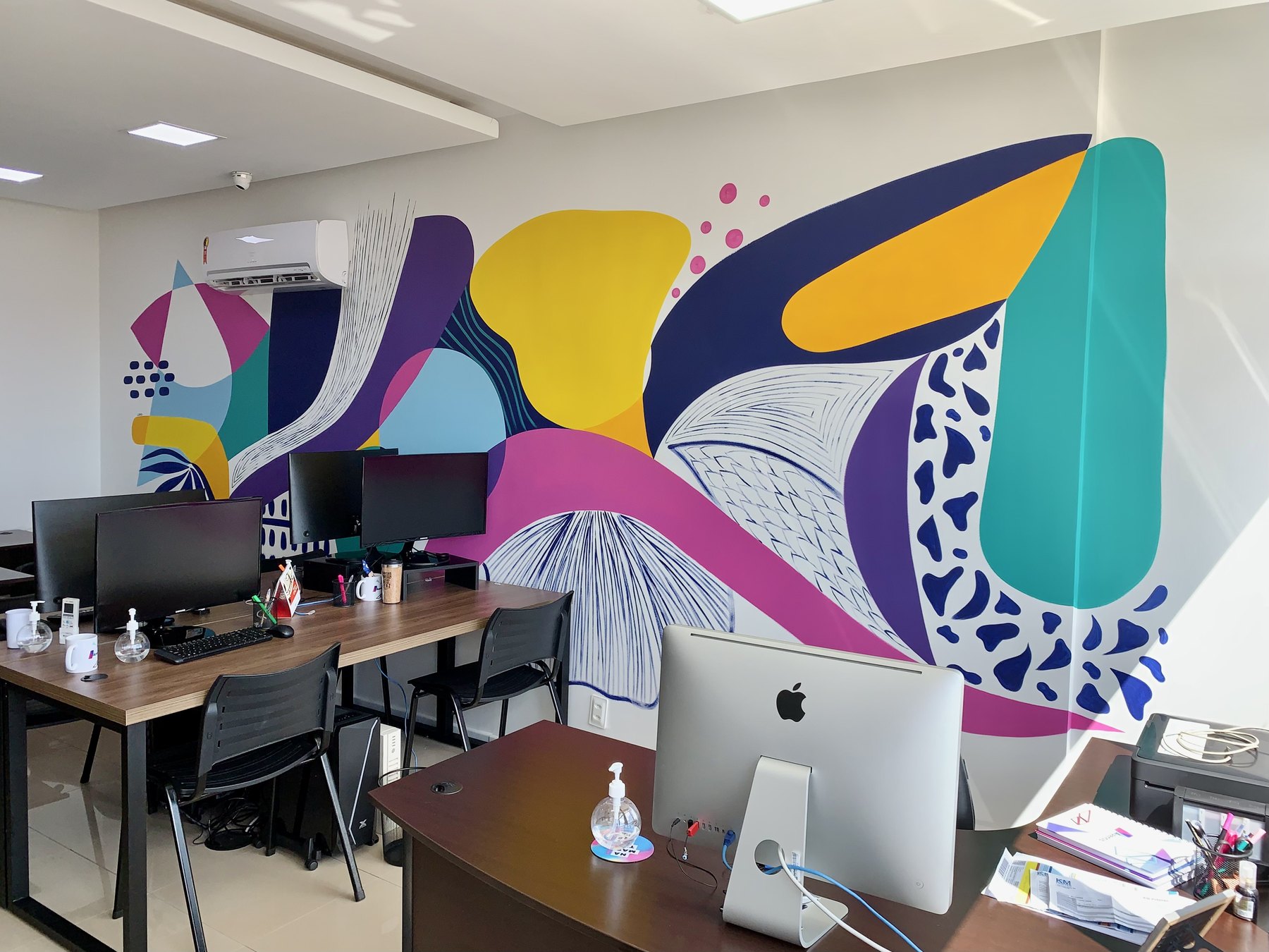 Intervenção mural colorida em ambiente de trabalho corporativo